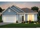 Charming single-story home with blue siding, a two-car garage, and beautifully landscaped front yard at 2500 Watershed Way, Longs, SC 29568