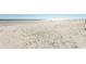 Wide sandy beach with gentle waves under a bright blue sky at 2507 S Ocean Blvd., North Myrtle Beach, SC 29582