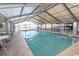 Indoor pool surrounded by lounge chairs, tables, and umbrellas, inside a glass-enclosed structure at 2507 S Ocean Blvd., North Myrtle Beach, SC 29582