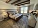Serene main bedroom with hardwood floors, ceiling beams, a large window, and stylish furnishings at 2521 Watershed Way, Longs, SC 29568