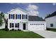 Charming two-story home with white siding, black shutters, attached garage, and manicured lawn at 296 Mayflower Dr., Calabash, NC 28467