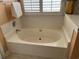Large soaking tub featuring plantation shutters and a neutral color palette at 3012 Winding River Rd., North Myrtle Beach, SC 29582
