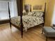 Primary bedroom boasts a four-poster bed with floral comforter and neutral walls at 3012 Winding River Rd., North Myrtle Beach, SC 29582
