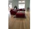 Open-concept living room with hardwood floors and stylish red sofas at 3012 Winding River Rd., North Myrtle Beach, SC 29582