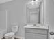 Bathroom features a toilet, vanity with sink, a large mirror, and neutral wall color at 36 Cape Point Dr., Conway, SC 29527
