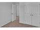 Bedroom with neutral carpet and paint, featuring closet doors, base trim, and interior door at 36 Cape Point Dr., Conway, SC 29527