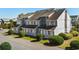 Charming townhouse with grey siding, black roof, and lush green landscaping on a sunny day at 3700 Golf Colony Lane # 6J, Little River, SC 29566