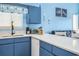Modern kitchen featuring blue cabinets, quartz countertops, and stylish decor, open to the living area at 3700 Golf Colony Lane # 6J, Little River, SC 29566