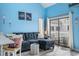 Comfortable living room with blue walls, nautical decor, and sliding door access to the balcony at 3700 Golf Colony Lane # 6J, Little River, SC 29566