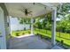 Covered patio with ceiling fan overlooking green grass, privacy fence, and green landscaping at 395 Dunbarton Ln., Conway, SC 29526