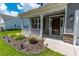 Charming front porch features stone accents, white railings, and a manicured lawn, creating an inviting entrance at 395 Dunbarton Ln., Conway, SC 29526