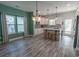 Open concept kitchen features gray backsplash, white cabinets, gray island with stools, and wood-look flooring at 395 Dunbarton Ln., Conway, SC 29526