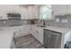Bright kitchen features white cabinets, modern stainless steel appliances, gray backsplash, and wood-look floors at 395 Dunbarton Ln., Conway, SC 29526