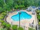 Aerial view of a kidney-shaped community pool with lounge chairs and seating areas, surrounded by lush greenery at 395 Dunbarton Ln., Conway, SC 29526