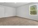 Well-lit bedroom with neutral carpet, white trim and a window overlooking greenery at 40 Cape Point Dr., Conway, SC 29527