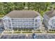 Aerial view of condo building showcasing multiple units and ample parking space at 4787 Wild Iris Dr. # 303, Myrtle Beach, SC 29577