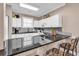 Modern kitchen with dark counters, seating, white cabinets, seamlessly connected to a dining area at 4787 Wild Iris Dr. # 303, Myrtle Beach, SC 29577