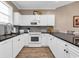 Well-equipped kitchen featuring white cabinets, black countertops and stainless steel appliances at 4787 Wild Iris Dr. # 303, Myrtle Beach, SC 29577
