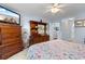Bedroom with dresser, TV, patterned bedding, and ceiling fan with light blue walls and white trim at 4818 Harvest Dr., Myrtle Beach, SC 29579
