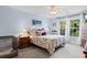 Comfortable bedroom featuring a floral-patterned bed, soft lighting, and a window with a view of the outdoors at 4818 Harvest Dr., Myrtle Beach, SC 29579