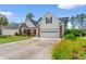 Home with a brick and white facade, manicured lawn, and a spacious driveway leading to the garage at 4818 Harvest Dr., Myrtle Beach, SC 29579