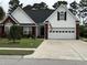 Charming home featuring brick accents, a well-manicured lawn, and a two-car garage at 4818 Harvest Dr., Myrtle Beach, SC 29579