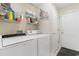 Well-organized laundry room equipped with a washer, dryer, shelving, and a door, offering convenience and functionality at 4818 Harvest Dr., Myrtle Beach, SC 29579