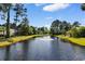 Scenic view of a community pond with a fountain surrounded by lush greenery and trees at 4818 Harvest Dr., Myrtle Beach, SC 29579