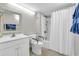 Clean, functional bathroom with white vanity, toilet with safety bars, and a shower/tub combination at 5806 N Ocean Blvd. # 203, North Myrtle Beach, SC 29582