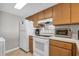 This kitchen includes wood cabinets, and white appliances, with tile flooring providing practical functionality at 5806 N Ocean Blvd. # 203, North Myrtle Beach, SC 29582