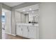 Wet bar with a sink, white cabinetry, and a mirror, conveniently located near the living area at 5806 N Ocean Blvd. # 203, North Myrtle Beach, SC 29582