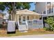 Charming yellow cottage with a welcoming front porch, string lights, and a cozy beach vibe at 6001 - 1820A S Kings Hwy., Myrtle Beach, SC 29575