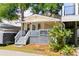 Charming yellow cottage with a welcoming front porch, string lights, and a cozy beach vibe at 6001 - 1820A S Kings Hwy., Myrtle Beach, SC 29575