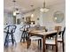 A view of the dining area, showing the bar and kitchen beyond it, with pendant lighting and seating for four at 612 N Ocean Blvd. # 103, Surfside Beach, SC 29575