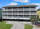 Three story building features balconies, white railings, and concrete driveway and green grass at 612 N Ocean Blvd. # 103, Surfside Beach, SC 29575