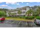 Three-story condo building with light siding, stairs, and palm trees at 6253 Catalina Dr. # 433, North Myrtle Beach, SC 29582