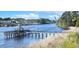 Picturesque view of a waterway with a charming fishing pier and distant bridge under a sunny sky at 637 Waterway Village Blvd. # 13C, Myrtle Beach, SC 29579