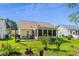 Charming backyard with screened porch, complemented by a lush lawn and mature trees at 6478 Royal Pine Dr., Myrtle Beach, SC 29588