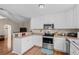 A contemporary kitchen features stainless steel appliances, white cabinets, and wood laminate flooring at 6478 Royal Pine Dr., Myrtle Beach, SC 29588