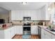 A kitchen features white cabinets, stainless steel appliances, and wood laminate flooring at 6478 Royal Pine Dr., Myrtle Beach, SC 29588