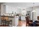 Bright kitchen with white cabinets, stainless steel appliances, breakfast bar, and glass top dining table at 6478 Royal Pine Dr., Myrtle Beach, SC 29588