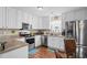 A bright kitchen features white cabinetry, stainless steel appliances, and a glass-topped dining table at 6478 Royal Pine Dr., Myrtle Beach, SC 29588