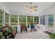 Bright sunroom with multiple windows, a ceiling fan, and a variety of comfortable seating options at 6478 Royal Pine Dr., Myrtle Beach, SC 29588