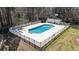 Aerial view of a pool with a surrounding fence and cabana in wooded area at 664 Tupelo Ln. # 8A, Longs, SC 29568