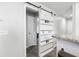 Hallway with wood floors and sliding barn door separating the living room from the hall and front door at 664 Tupelo Ln. # 8A, Longs, SC 29568