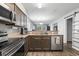 Open kitchen featuring stainless steel appliances, stone countertops, wood floors, and lots of natural light at 664 Tupelo Ln. # 8A, Longs, SC 29568