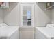 Clean, bright laundry room featuring a window with two appliances and wire shelving at 664 Tupelo Ln. # 8A, Longs, SC 29568