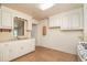 View of the kitchen featuring wooden floors and white cabinetry, offering ample storage and functionality at 704 N North Congdon St., Georgetown, SC 29440