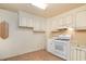 Image of the kitchen, displaying the white appliances and cabinets, and wooden floors in the space at 704 N North Congdon St., Georgetown, SC 29440