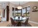 Bright breakfast nook features a glass table and serene backyard views through large bay windows at 7253 Seville Dr., Myrtle Beach, SC 29572